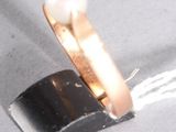 une bague renfermant une perle, posée sur un morceau de métal