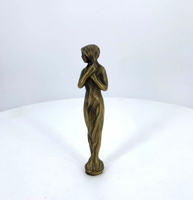 bronze statue of a woman holding her hands to her face