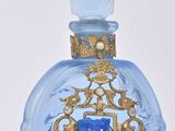 une bouteille en verre bleue ornée d'un motif doré