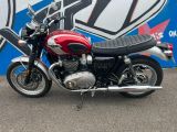 a red and black motorcycle parked in front of a blue and white sign