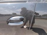 a reflection of a man in a mirror on the door of a car