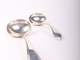 two spoons that are sitting next to each other