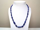 collier composé de perles de verre bleues sur un mannequin blanc