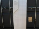 une boîte sur laquelle est collé un autocollant, posée sur une étagère