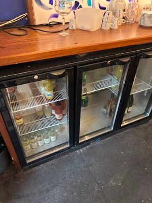 un petit réfrigérateur sur lequel sont posées de nombreuses bouteilles