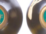 two black vases with gold and green designs on them