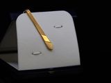 a gold pen sitting on top of a white box