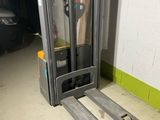 a fork lift truck parked in a garage next to a wall