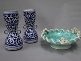 two vases and a bowl sitting on a table