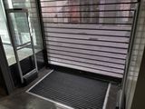 une porte noire munie d'une grille métallique