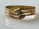 two gold rings with diamonds on them sitting on top of a white surface