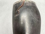 a black vase that has a rope on it
