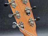 the headstock of an acoustic guitar with strings attached to it