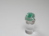 a close up of a ring with a green stone in it