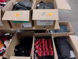 Plusieurs cartons de vêtements sont empilés les uns sur les autres