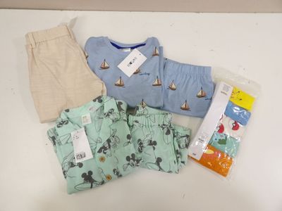 a baby boy ' s clothing on a table next to other items