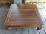 a wooden table with a square top on a wooden floor