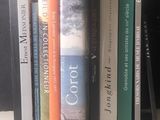de nombreux livres posés sur une étagère devant un ordinateur portable