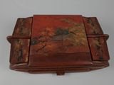 an old wooden box with a painting on it sitting on a table