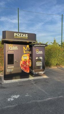 two pizzas that are sitting on the side of the road