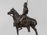 statue représentant un homme à cheval, muni d'une lance, posée sur un socle en bois