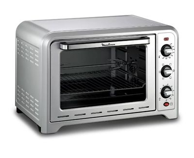 four grille-pain argenté sur fond blanc, avec une grille placée devant