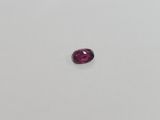 a pink tourmaline stone on a white surface