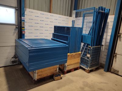 une palette bleue posée dans un entrepôt, contre un mur