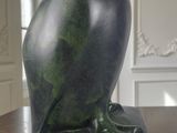 statue of an owl sitting on a wooden table in a room
