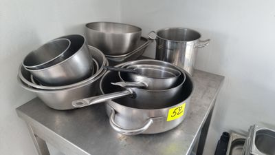 de nombreuses casseroles et poêles posées sur une table en métal