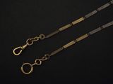 a close up of two gold chains on a black background