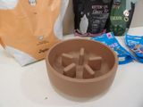 a bowl of cat food next to a bag of cat food