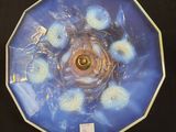 une photo d'une assiette bleue ornée de fleurs blanches