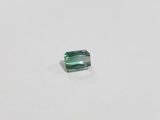a green tourmaline stone on a white surface