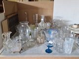 des bouteilles et des verres posés sur une table dans une cuisine où se trouve un réfrigérateur