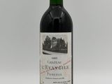 a bottle of red wine sitting on top of a white table
