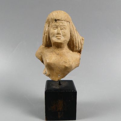 une petite statue représentant une femme aux cheveux longs, posée sur un socle en bois