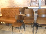 several chairs and a couch in a room with a brick wall