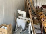 a pile of junk in a garage next to a toilet