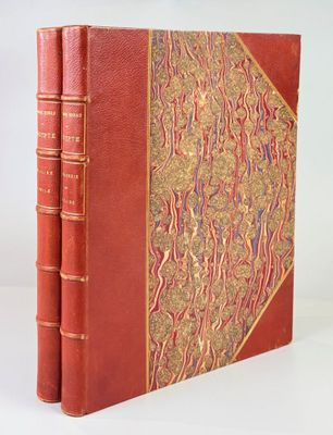 an old red book with gold trim and a decorative cover