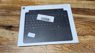 une boîte contenant un clavier noir posée sur une table en bois