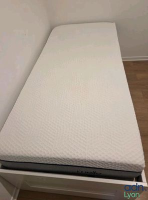 a small bed with a laptop on top of it