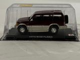 a toy car in a clear case on a white surface