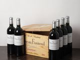 plusieurs bouteilles de vin posées sur une table à côté d'une caisse en bois