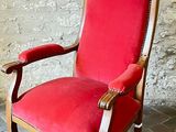 une chaise rouge posée devant un mur de briques