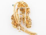 an image of a gold broochle with flowers and leaves