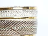 a close up of a silver and gold bowl on a table