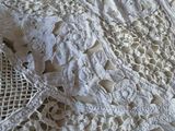 a close up of a white lace on a bed