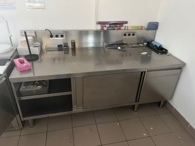 une grande cuisine en inox équipée d'un évier et d'une cuisinière