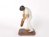 figurine of a man holding a baseball bat on top of a wooden base